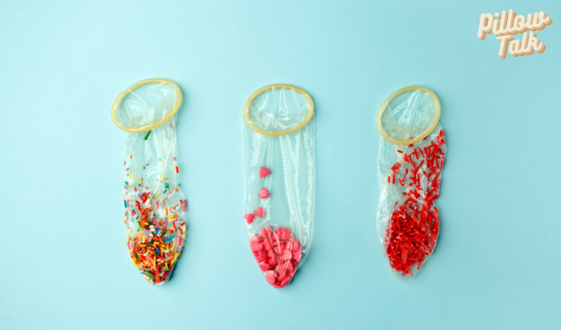 A light blue backgound with 3 unrolled condoms in a row with sprinkles of different colors in each one
