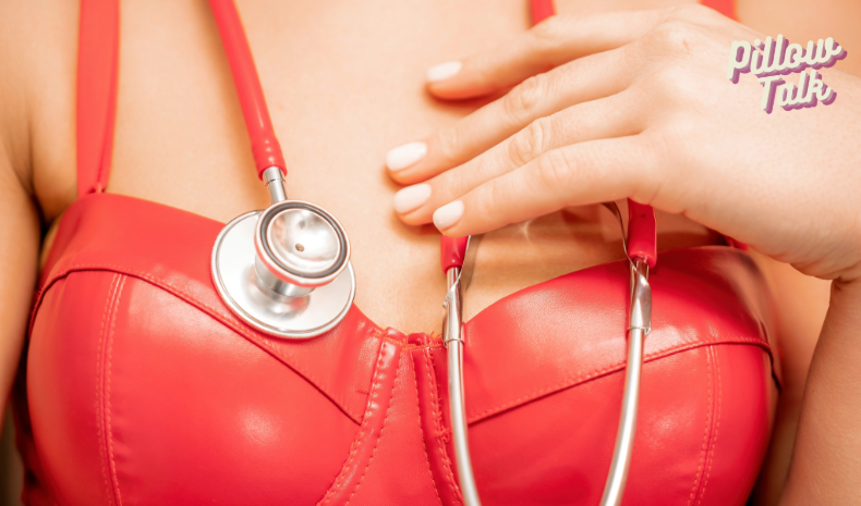 The chest area of a light skinned woman in a sexy red leather top with a stethoscope 